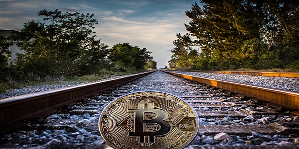 gold colored bitcoin on rail road