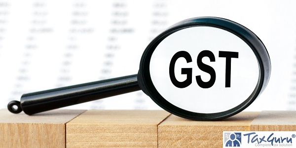 Looking through a magnifying glass at the word GST, a business concept