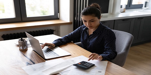 Independent women working on Laptop with pen and Calculator