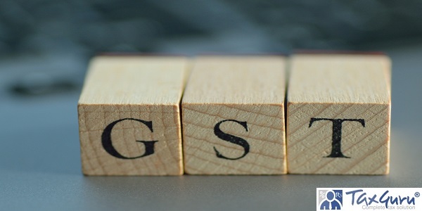 GST written on wooden blocks with blurred note pc background