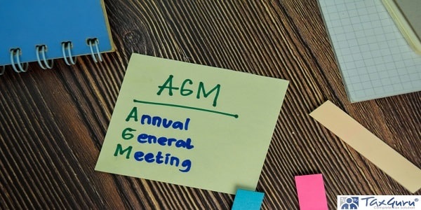AGM - Annual General Meeting write on notes isolated on Wooden Table