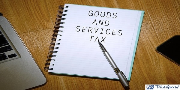 GST Goods And Services Tax - Notebook with laptop and smartphone on wooden table