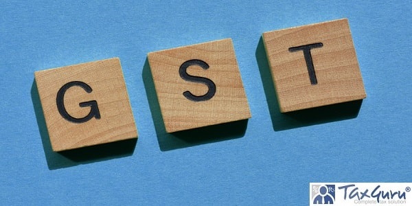 GST, acronym for Goods and Services Tax, in wooden alphabet letters isolated on blue background as banner headline