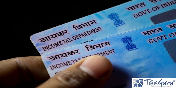 PAN identification ID card of India held in hand on black background