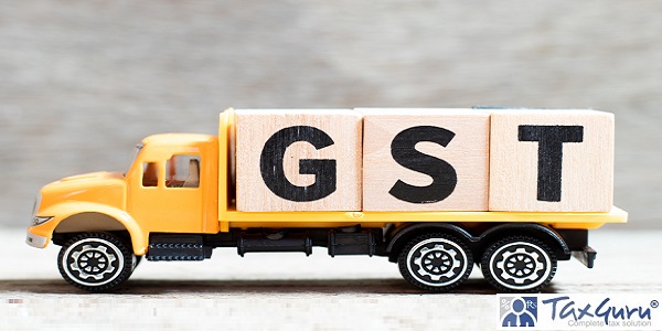 Truck hold letter block in word GST (Abbreviation of Goods and Service Tax) on wood background